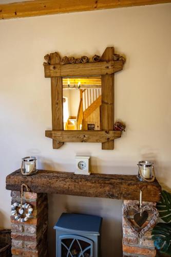 a mirror on a wall above a fireplace at The Barn, rustic country cottage dog friendly in Whitby