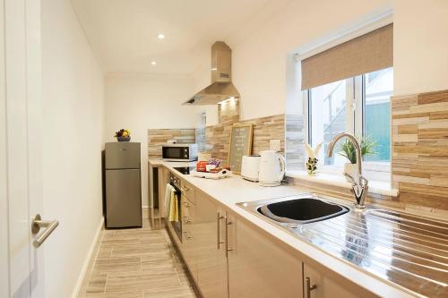 a kitchen with a sink and a refrigerator at The Court Yard Apartment - Fantastic location! in Scarborough