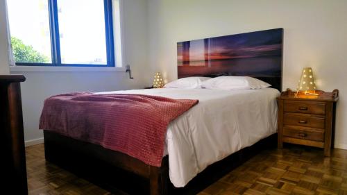 a bedroom with a large bed and a wooden dresser at Amorosa Beach Apartment Family in Viana do Castelo