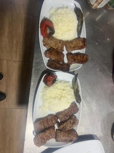 two plates of food with meat and rice on a table at Vələs Garden in Quba