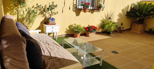 a living room with a couch and a glass table at Relax & home, apartamento con terraza y parking in La Zubia
