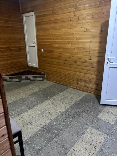 a room with a wooden wall and a door at Vələs Garden in Quba