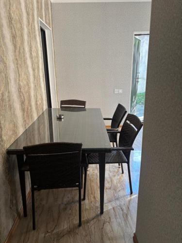 a dining room table with black chairs and a glass table at Vələs Garden in Quba