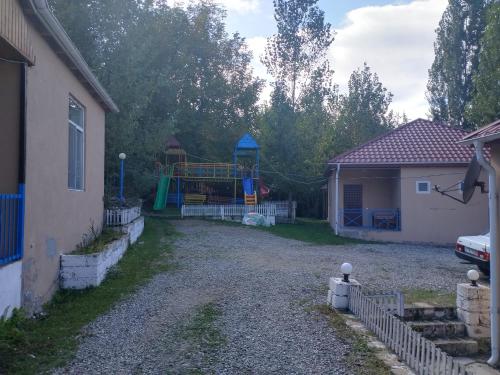 a playground in a yard next to a house at Vələs Garden in Quba