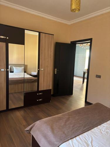 a bedroom with a bed and a large mirror at Vələs Garden in Quba