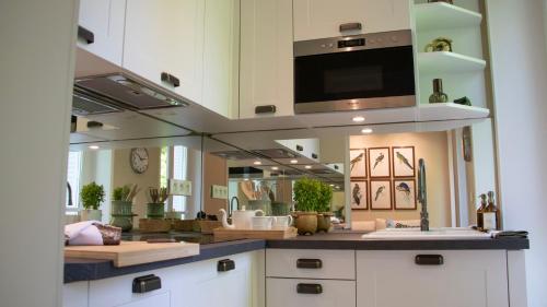 - une cuisine avec un évier et un grand miroir dans l'établissement Le Perroquet qui Bulle - Reims Centre, à Reims