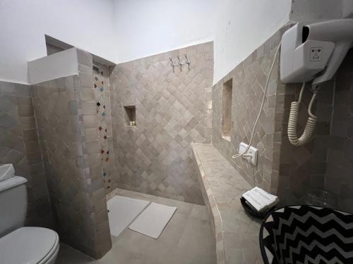 a bathroom with a shower with a toilet and a phone at Riad Jnan El Cadi in Marrakech