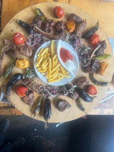 a plate of food with vegetables and french fries at Vələs Garden in Quba