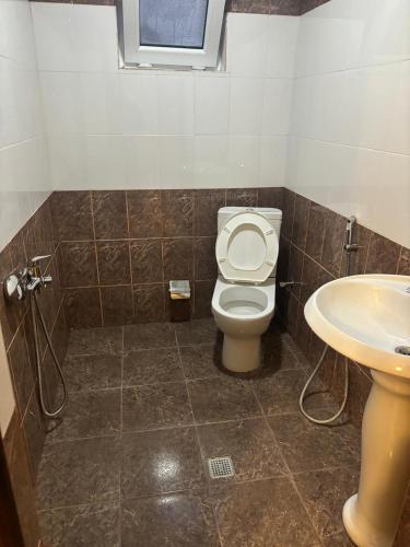 a bathroom with a toilet and a sink at Vələs Garden in Quba