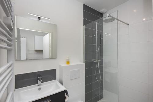 une salle de bain avec un lavabo et une douche avec un miroir dans l'établissement Lambig, à Brest