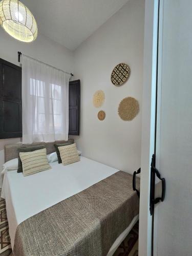 a bedroom with two beds and two windows at La Gitanilla Alojamiento & Encanto Jerez in Jerez de la Frontera