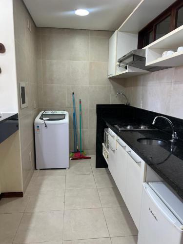 a kitchen with a sink and a small refrigerator at Kariri Beach Residence in Caucaia