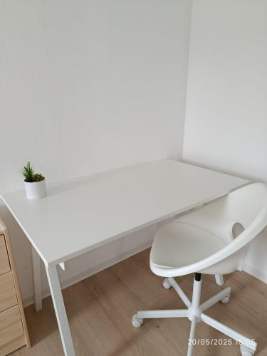 a white desk and a chair in a room at book2stay - Apartments Herisau in Herisau