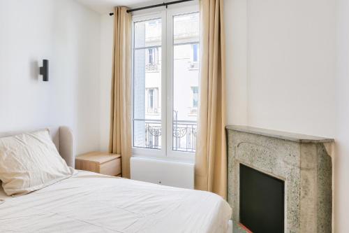 une chambre avec un lit et une cheminée dans l'établissement Appartement 2 Pièces I 8 min à pied de la Défense, à Courbevoie
