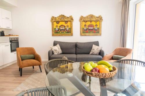 a living room with a table with a bowl of fruit at Taormela 1 - Holiday Apartment in Taormina