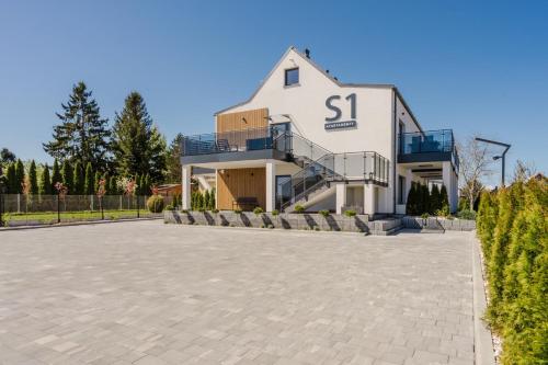a large white building with a s sign on it at S1 Apartamenty Rewa in Rewa