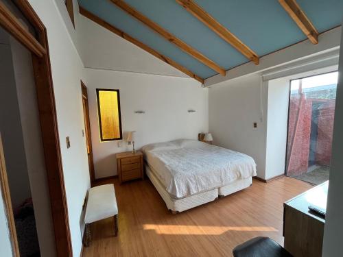 a bedroom with a bed and a table and a window at Hostería Vitacura in Santiago