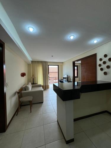 a living room with a kitchen and a couch in a room at Kariri Beach Residence in Caucaia