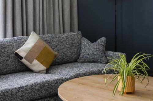 a couch with pillows and a table in a living room at voco Belfast by IHG in Belfast