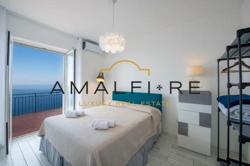 コンカ・デイ・マリーニにあるCasa Tiberioのベッドルーム1室(ベッド1台付)、海を望むバルコニーが備わります。