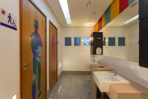 baño con 2 lavabos y una pared colorida en Go Inn Vitória, en Vitória