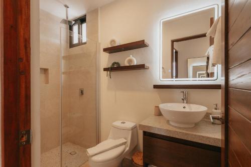 a bathroom with a toilet and a sink and a mirror at Casa Reina Tulum in Tulum