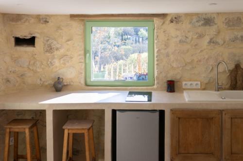 une cuisine avec un évier et une fenêtre dans l'établissement La lussanaise, à Lussan