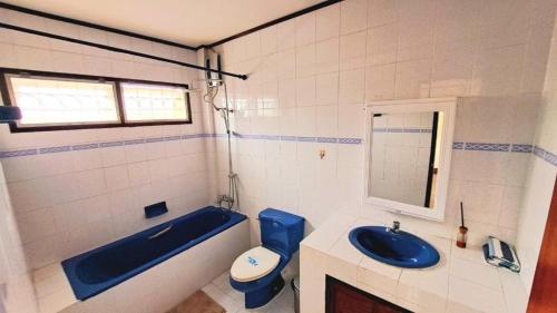a bathroom with a blue tub and a toilet and a sink at TheStarHome Sukhumvit71 in Bangkok