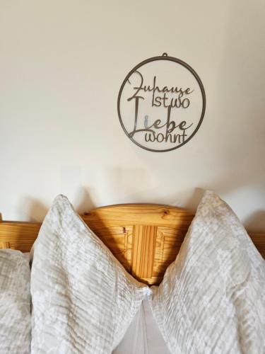 a bedroom with a bed with a sign on the wall at Apartment Sommer am Faaker See in Faak am See