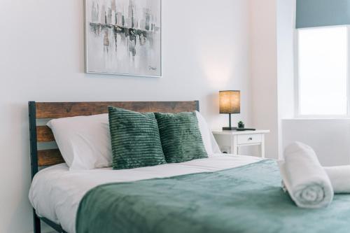 a bedroom with a bed with green and white pillows at 3 Bedroom House Workstays UK in Middlesbrough