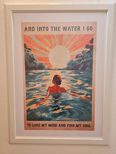 a framed poster of a man swimming in the water at Apartment Sommer am Faaker See in Faak am See