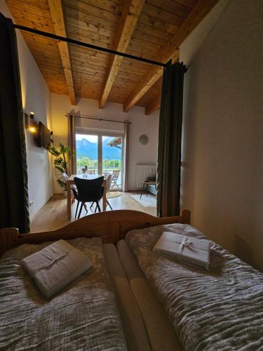 a bedroom with two beds and a table with a view at Apartment Sommer am Faaker See in Faak am See