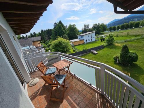 a balcony with two chairs and a table on it at Apartment Sommer am Faaker See in Faak am See