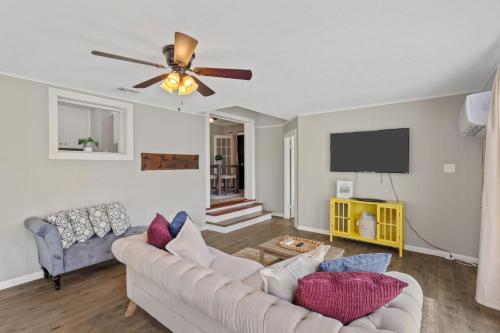 a living room with a couch and a ceiling fan at Downtown Cottage in Lake Charles