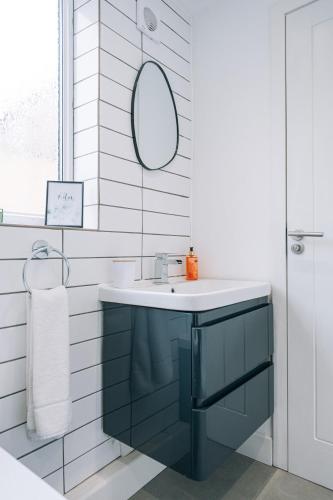 a bathroom with a blue sink and a mirror at 3 Bedroom House Workstays UK in Middlesbrough