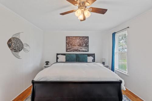 a bedroom with a bed and a ceiling fan at Downtown Cottage in Lake Charles