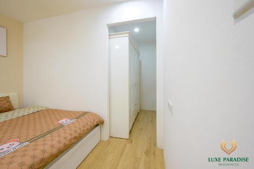 a small bedroom with a bed and a hallway at Paradise Hotel & Apartment 51TDT by Luxe Hospitality in Hanoi