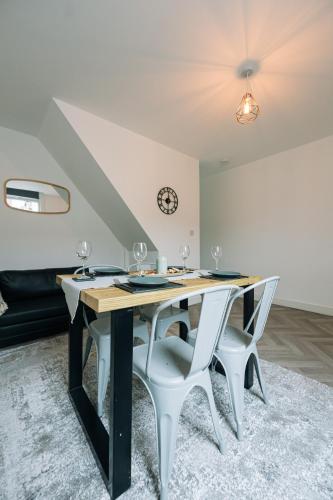 a dining room with a table with wine glasses on it at 3 Bedroom House Workstays UK in Middlesbrough