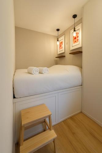 - une petite chambre avec un lit et un tabouret en bois dans l'établissement Malpalu St Maclou centre Rouen Linges et ménage inclus, à Rouen