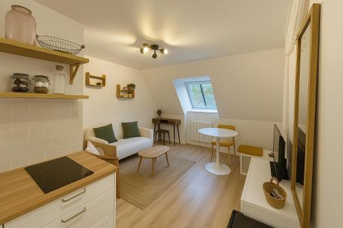 a kitchen and living room with a couch and a table at Malpalu St Maclou centre Rouen Linges et ménage inclus in Rouen