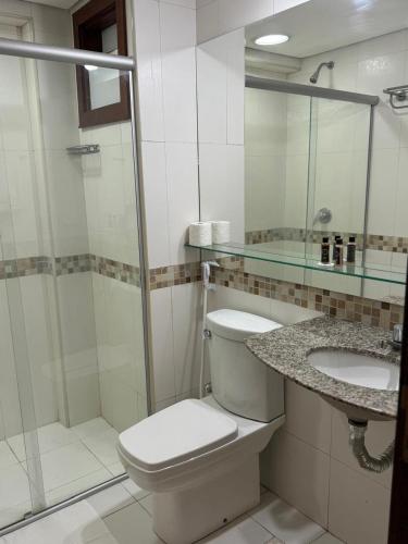 a bathroom with a toilet and a sink and a shower at Kariri Beach Residence in Caucaia