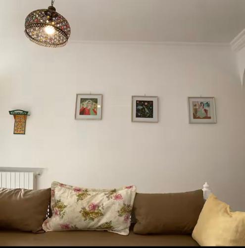 a couch in a living room with pictures on the wall at deux Studio avec patio a Sidi Bousaid in Dar Salah Bey
