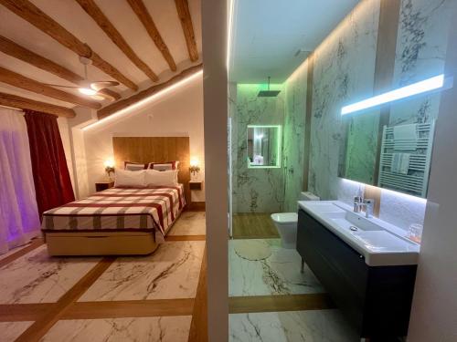 a bedroom with a bed and a sink and a bathroom at Los Chicos de Lastanosa Hotel y Restaurante in Lastanosa