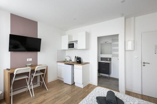 - une cuisine blanche avec une table et un comptoir dans l'établissement Pommeau, à Brest