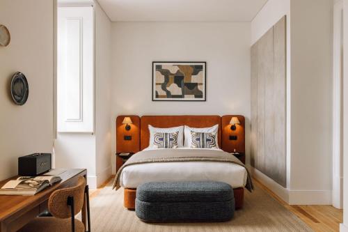 a bedroom with a bed with a wooden headboard and a table at Ando Living - Corpo Santo House in Lisbon
