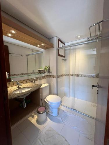 a bathroom with a toilet and a sink and a shower at Kariri Beach Residence in Caucaia
