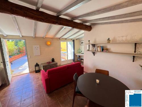 a living room with a red couch and a table at VILLA HORUS - Bergerie 1chambre - piscine privée in San-Gavino-di-Carbini