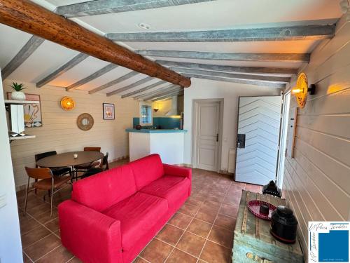 a living room with a red couch and a table at VILLA HORUS - Bergerie 1chambre - piscine privée in San-Gavino-di-Carbini