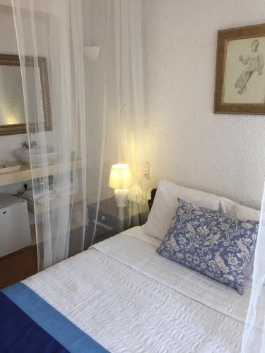 a bedroom with a bed with a blue pillow at Porto Maltese Boutique Estate in Agios Nikolaos