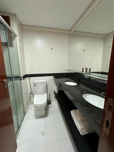 a bathroom with two sinks and a toilet at Kariri Beach Residence in Caucaia